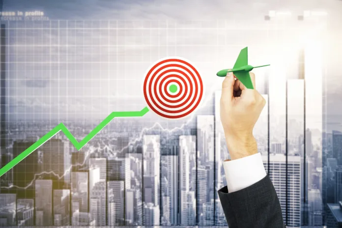 Businessman aiming a green dart at a target symbol over a rising graph and city skyline, symbolizing growth through Target Account Selling strategy.